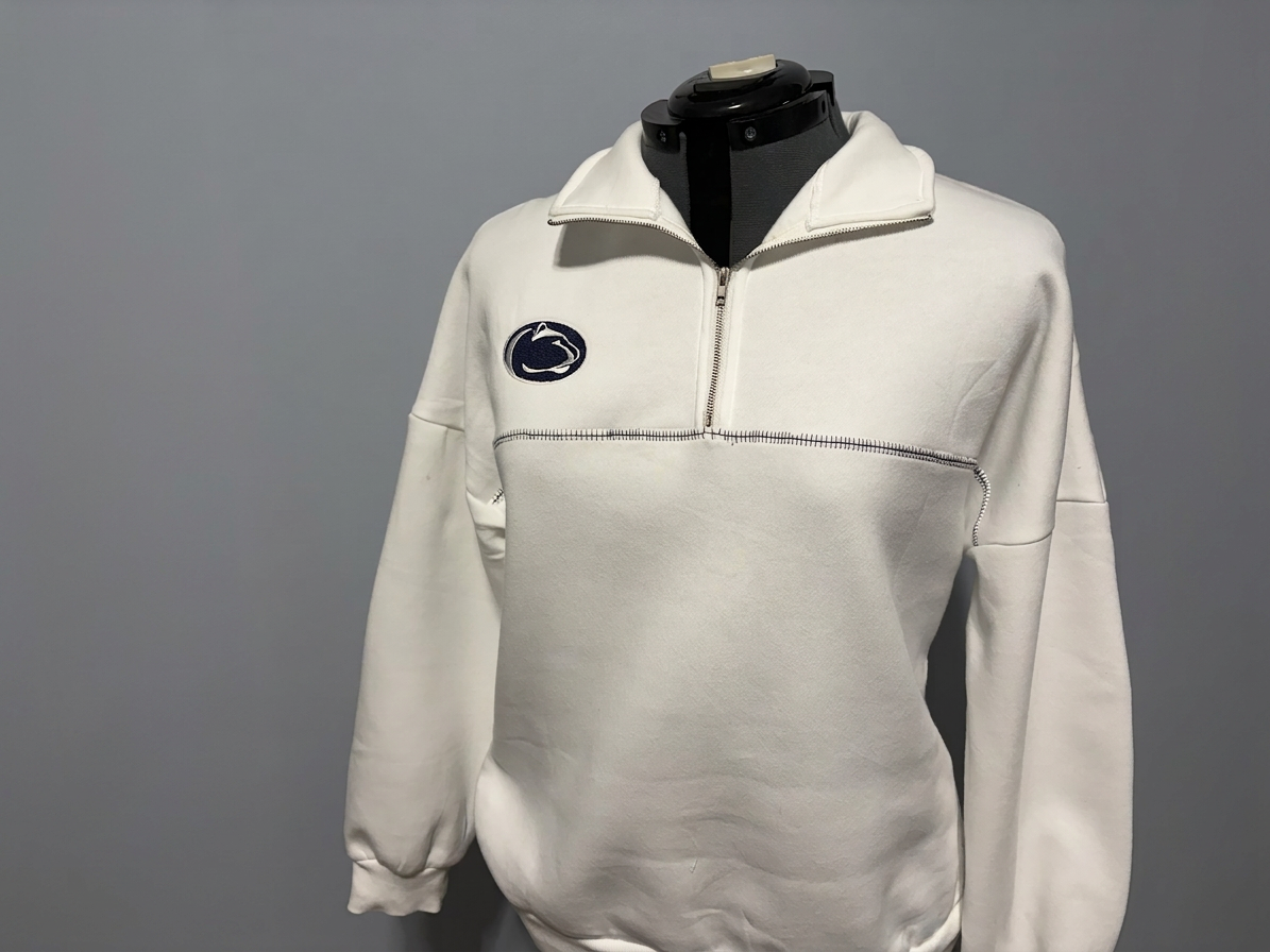 img_0891 White zip-up sweatshirt with an embroidered logo on the chest, displayed on a mannequin against a gray background.